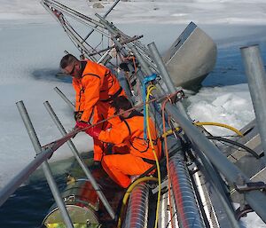 Two tradies in floatation suits on the melt bell pontoon