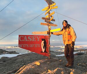 Conrad standing at Casey sign at sunset