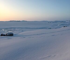 Snow and ice across the bay with a few exposed rocks