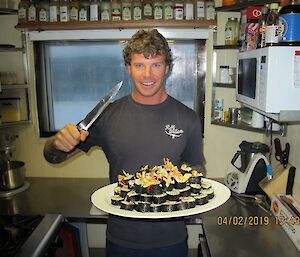 Ben holding a plate of sushi that he prepared in the Wilkins kitchen