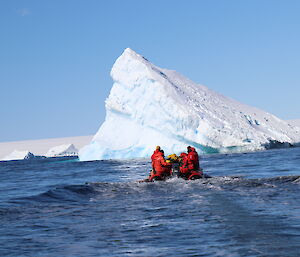 following another boat heading towards an iceberg on a beautiful, clear day