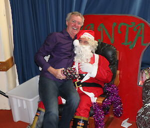 Jason sitting on Santa’s lap receiving a gift