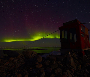 Aurora with Jack’s Hut in the forwegound with the aurora reflecting on the water