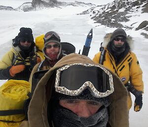 Big Al,Wilkens Matt,Bom Craig,and I on the lookout for elephant seals near Browning’s in their field gear with rocks and ice in the background