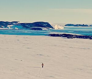 Heading back to Robbo’s hut across an expanse of snow with water in the background after exploring local surrounds