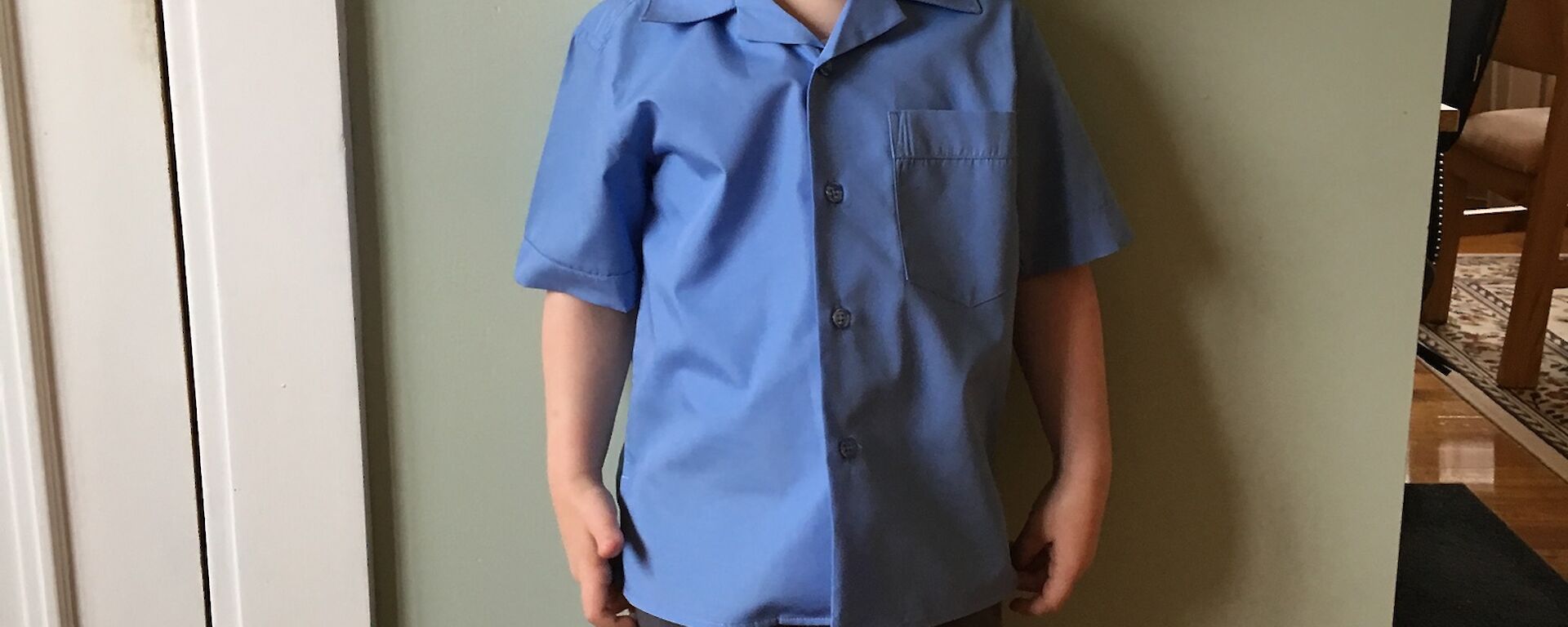 Scott’s son Daniel ready for his first day at school standing against a wall all dressed up