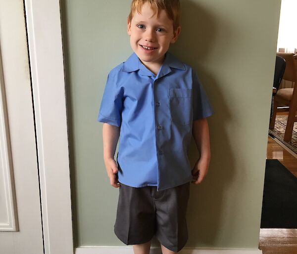 Scott’s son Daniel ready for his first day at school standing against a wall all dressed up