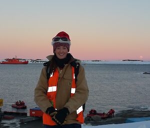 Amy down at the wharf with Aurora Australis in the background at sunrise