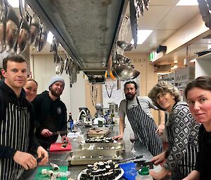 Cooking class with Chef Jordan. Students Ben, Aaron, Juan, Chris and Tanya stanidng in the kitchen. Franko and Jason not shown