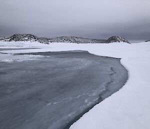 Sea ice with a large carved out section with island in background