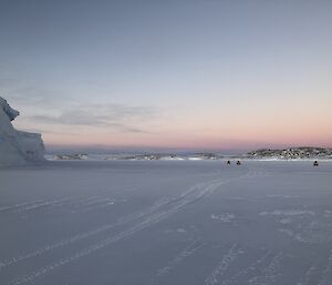 Three quads on the ice with an ice cliff on the left and island on the right