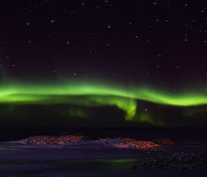 A bright green aurora across the horizon