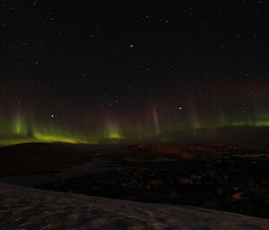 An aurora across the horizon of green and red