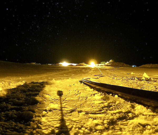 A long black hose lying across the snow with the Station in the background