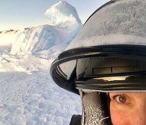 Jords with an iceberg stuck in sea ice behind Jordan whilst Quad Sea Ice Training