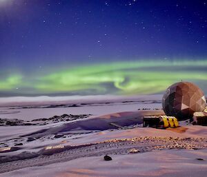 A green aurora over the ANARESAT building at Casey