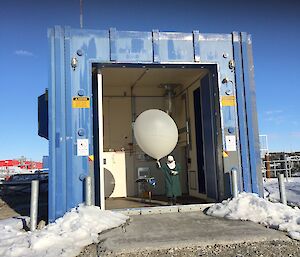 Evan walking the Weather Balloon and radiosonde outside through the giant Balloon Shed doors