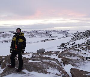 Juan standing on rocks with snow, rocks and ice in the background