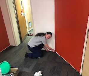 Passing expeditioner symbolically places the final piece of grey carpet tile against a wall for the upper renovations