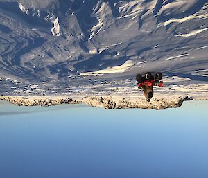 Three quads shown being ridden on the sea ice with an island in the background