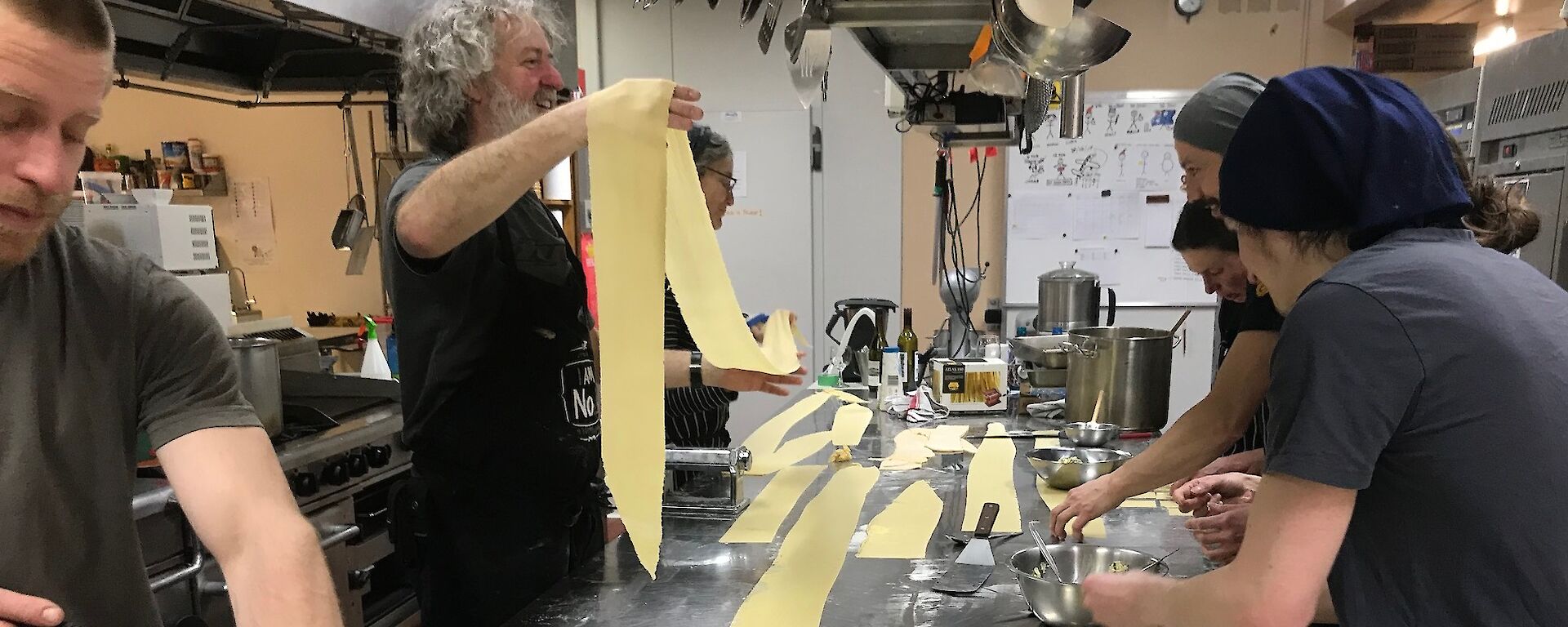 Multiple sheets of pasta being laid out in the kitchen