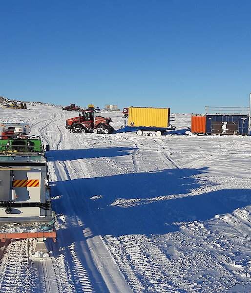 Several vehicles towing trailers departing Station on a sunny, clear day