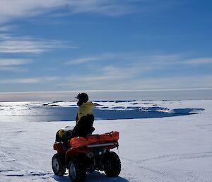 Chris on a quad with a bay in the background on a beautiful sunny day