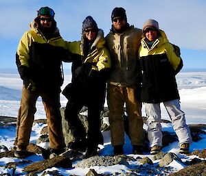 Gavin, Chris, Scott and Tanya standing on rock with ice cliffs and blue sky in the background