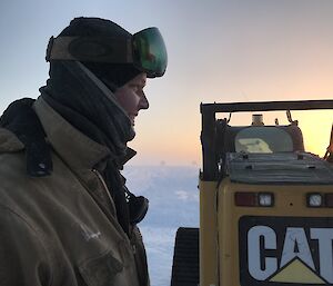 A profile of Josh at Wilkins with a Cat machine in the background