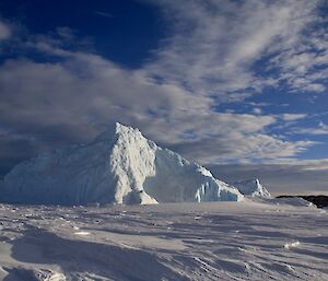 an iceberg in the sea iceunder a sunny sky