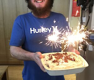 James holding a birthday cake with sparklers