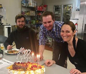 Conrad, Jordan and Aaron looking at a pavlova with candles and a birthday sign