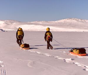 Two expeditioners towing sleds on a sunday day on the sea ice