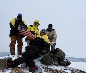 Franko, Tanya, Chris and Rex visiting the Memorial plaque and cairn marking the American landing 19 Jun 1948 on Peterson Island holding an American Flag