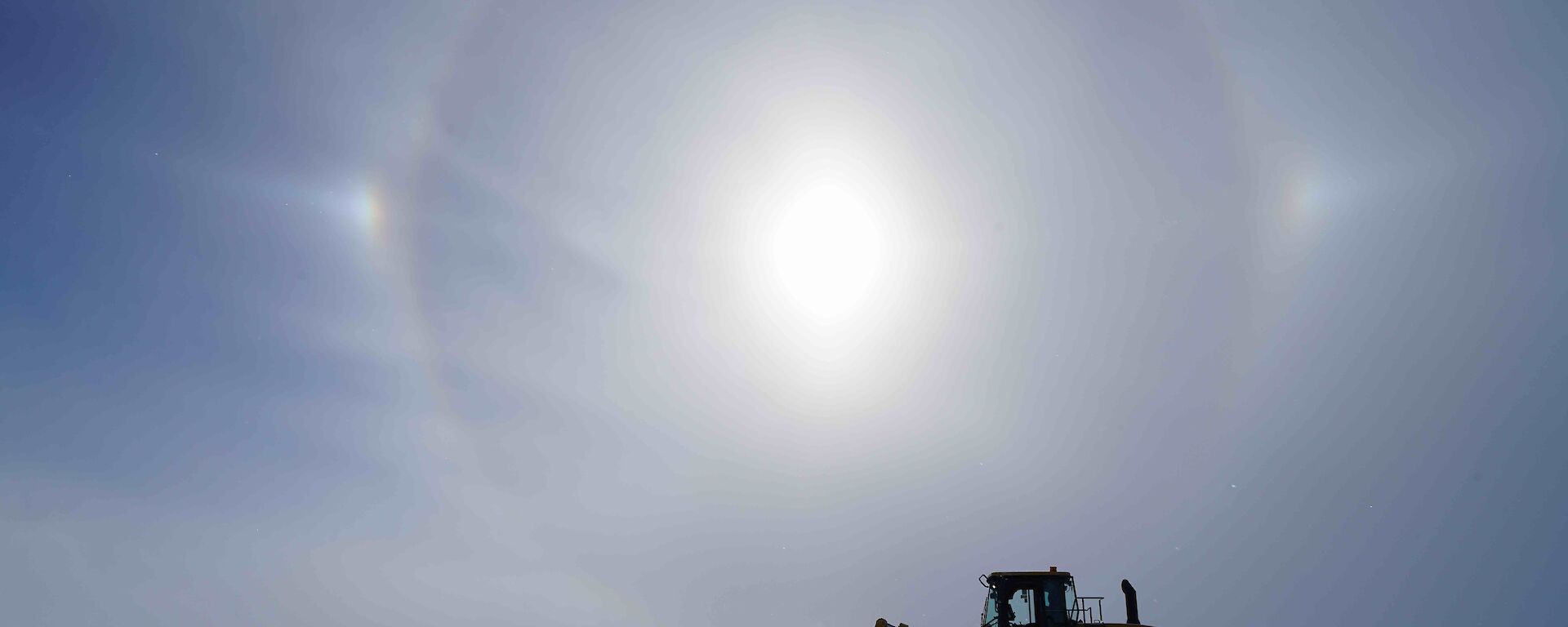A loader and a team of workmen doing repairs on the runway