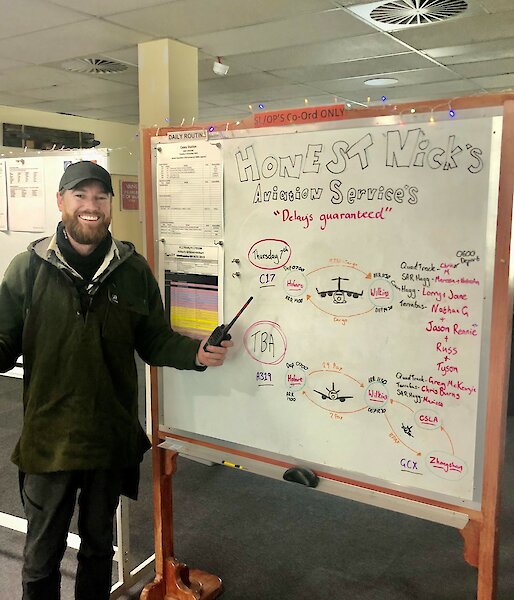 Nick Watt this years Operations Coordinator stands next to one of the white boards he has set up with operational information in the wallow at Casey