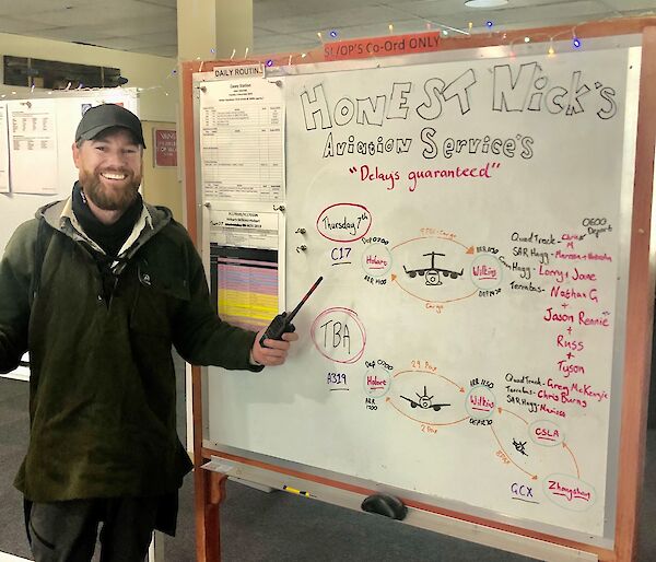 Nick Watt this years Operations Coordinator stands next to one of the white boards he has set up with operational information in the wallow at Casey