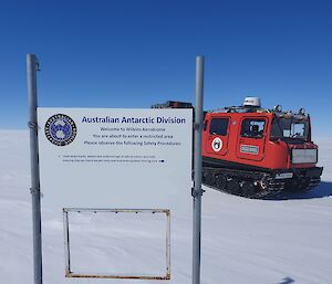 The red SAR Hagg behind the Wilkins Aerodrome sign on the ice plateau