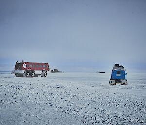 A large red all-terrain bus (the Terrabus) is driving away, followed by a blue Hägglunds vehicle