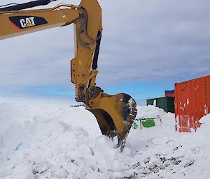 An excavator digging containers out of the winter snow at Casey