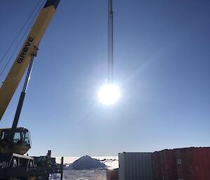 Arty shot of the crane appearing to lift the sun