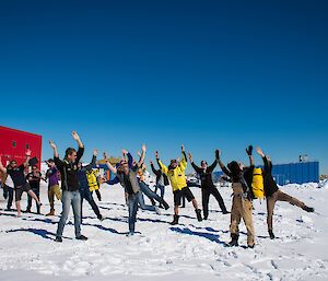 The Casey expeditioners waving to the qantas plane outside the Red Shed at Casey