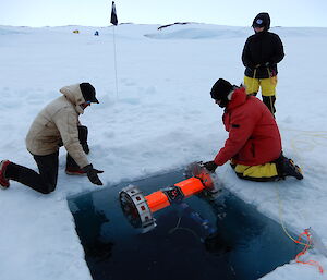 two people retrieving the NASA robot from the sea ice.