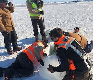 the team assisting in digging a hole in the sea ice for the Tide Gauge calibration project at Casey