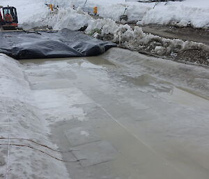 The biopile barrier system showing the black high density polythene primary barrier and the beige geosynthetic clay liner (GCL) as the secondary barrier below