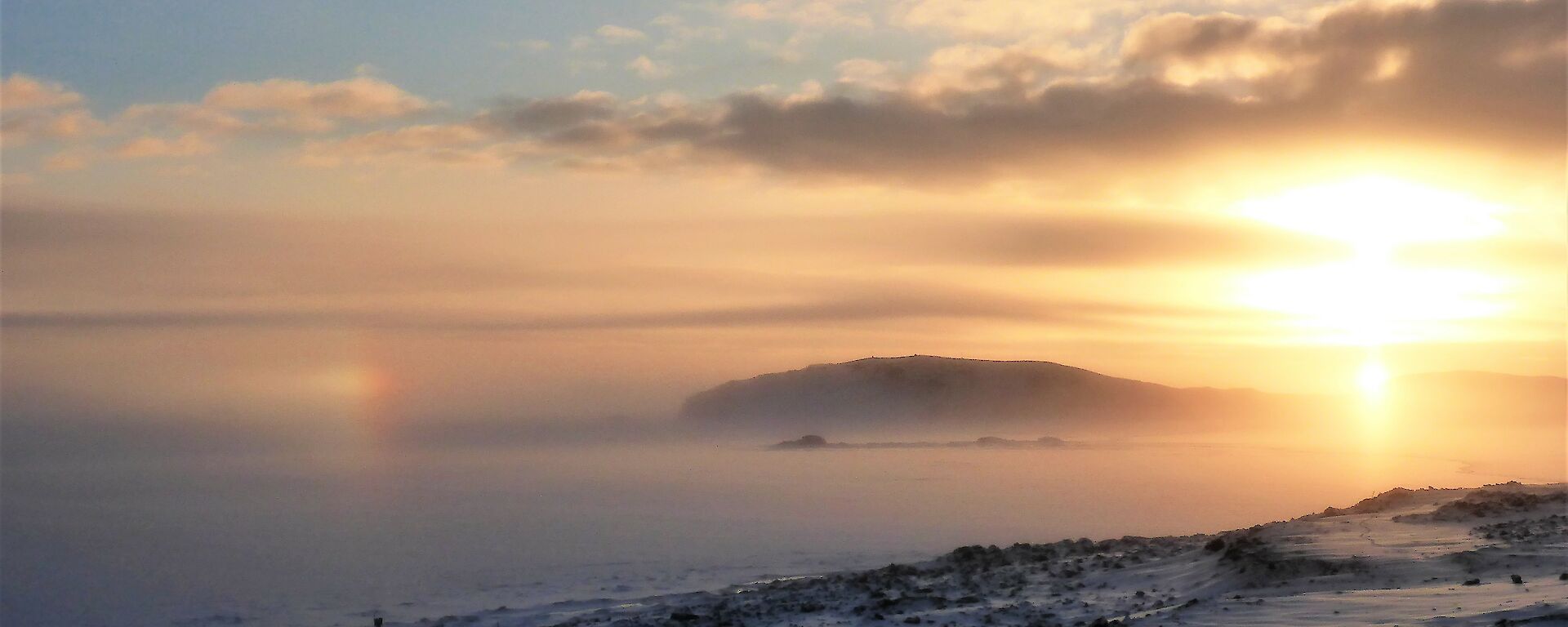 Low sun over foggy ice