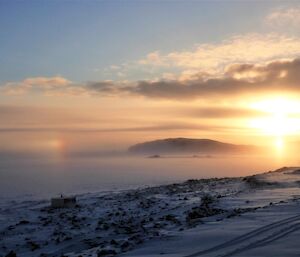 Low sun over foggy ice