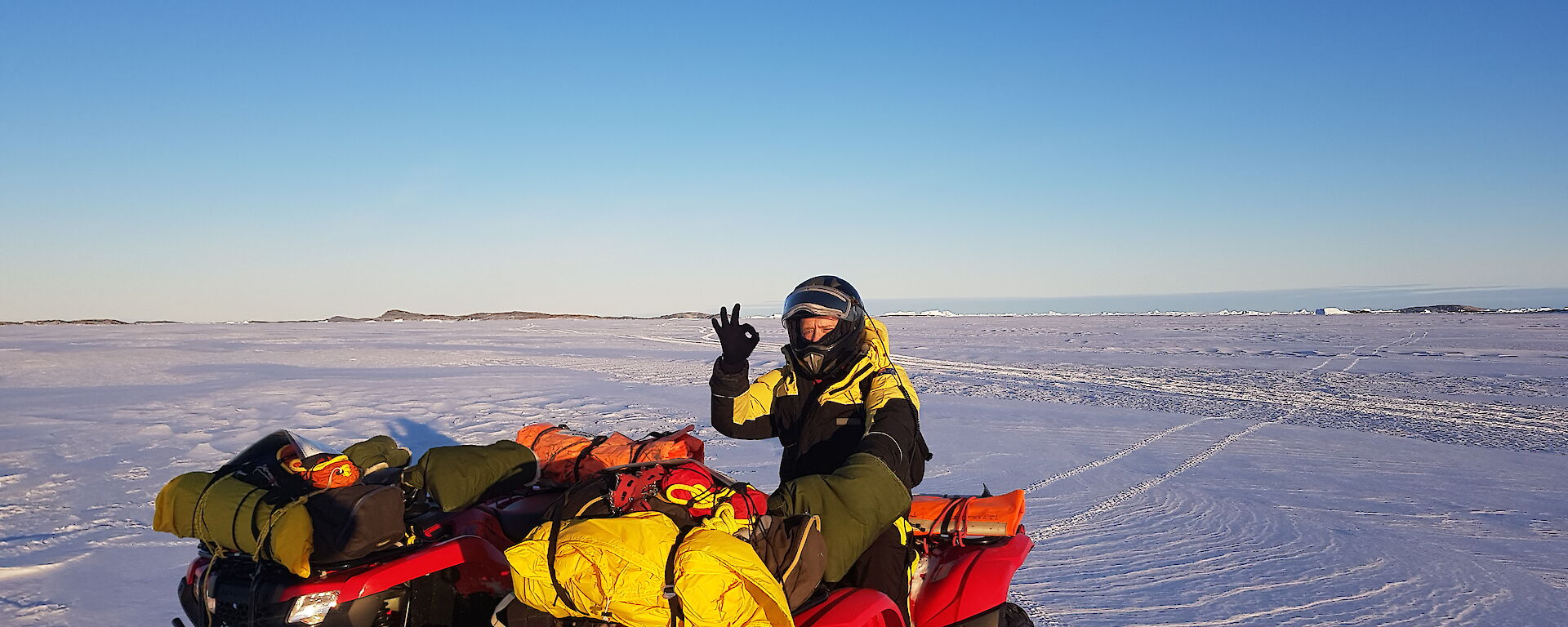 Antarctic expeditioner on quad bike