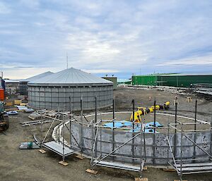 The tanks first, grey wall panels held firmly in position by scaffolding