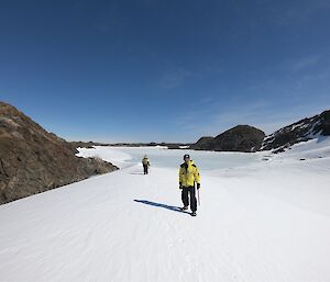 Station Leader Dave holds an ice axe and walks up a snow covered bank